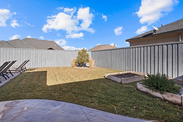 view of yard with a fenced backyard, a patio area, and a vegetable garden