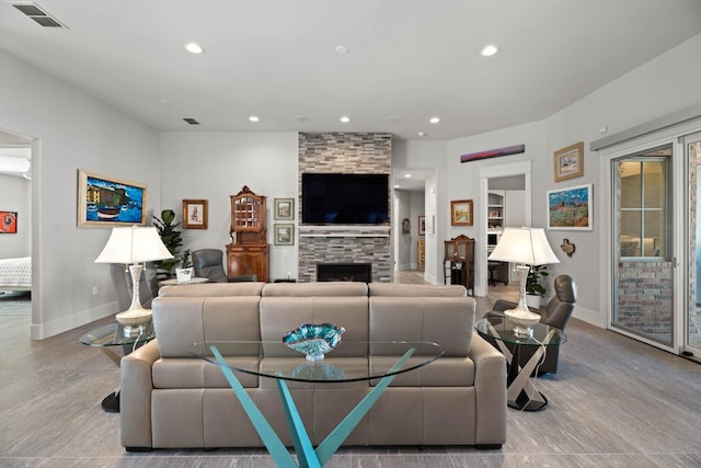 living room with recessed lighting, visible vents, baseboards, and a stone fireplace