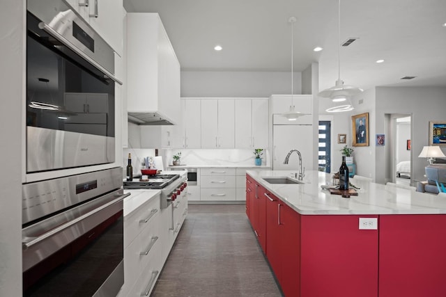 kitchen featuring a sink, visible vents, custom exhaust hood, decorative backsplash, and modern cabinets