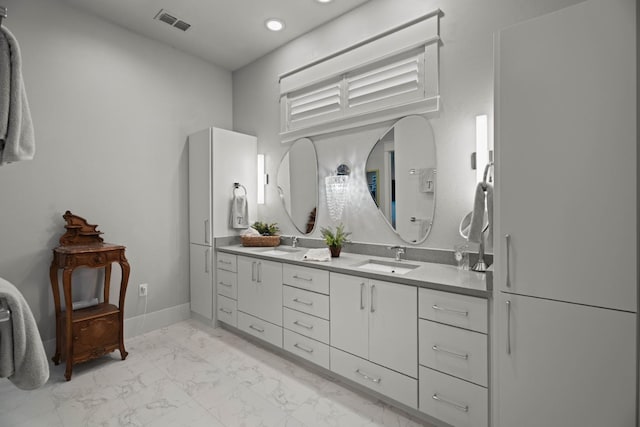 bathroom featuring double vanity, marble finish floor, visible vents, and a sink