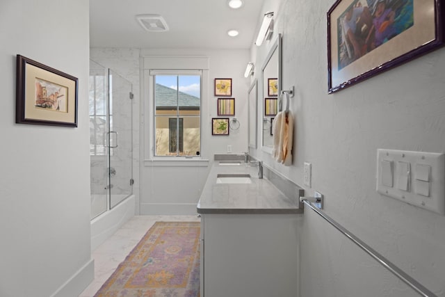 bathroom featuring shower / bath combination with glass door, a sink, baseboards, marble finish floor, and double vanity