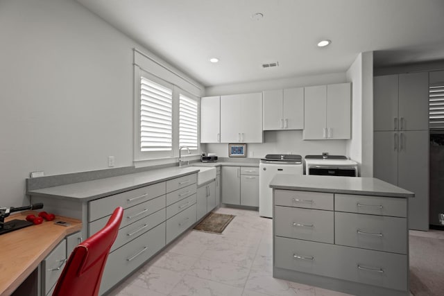 kitchen with visible vents, stove, marble finish floor, a sink, and recessed lighting