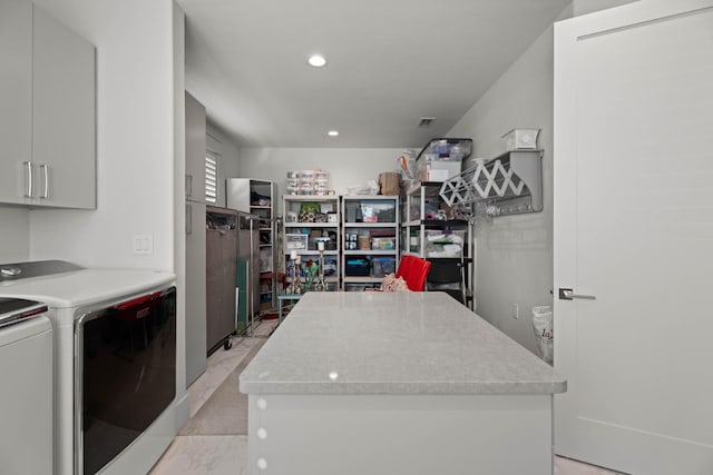 kitchen with recessed lighting, light countertops, a kitchen island, and washer and clothes dryer