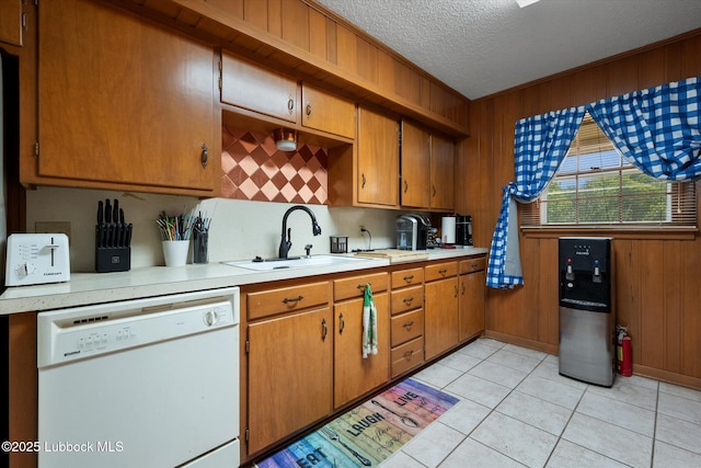 5426 28th St, Lubbock, TX 79407 - kitchen featuring white dishwasher, light countertops, a textured ceiling, brown cabinetry, and decorative backsplash