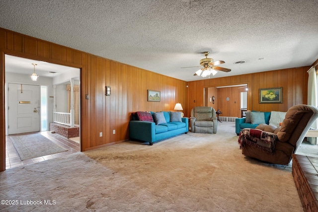 5426 28th St, Lubbock, TX 79407 - living room featuring carpet floors, ceiling fan, wood walls, and a textured ceiling
