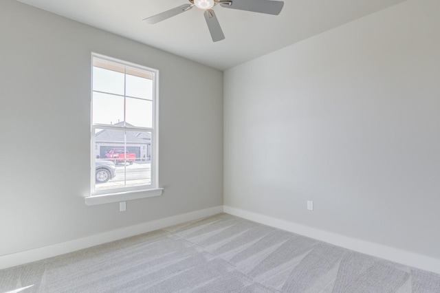 empty room with ceiling fan and light carpet