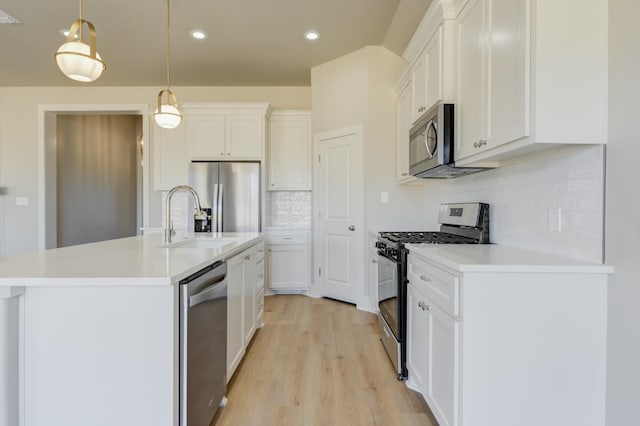 kitchen with decorative backsplash, white cabinets, and appliances with stainless steel finishes