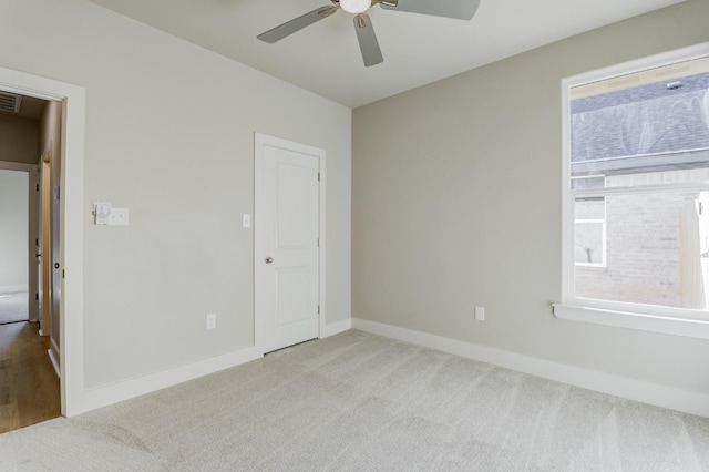 carpeted empty room featuring ceiling fan