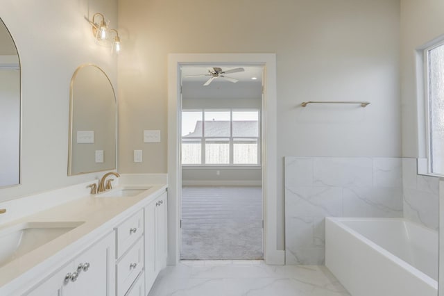 bathroom featuring ceiling fan, vanity, and a tub