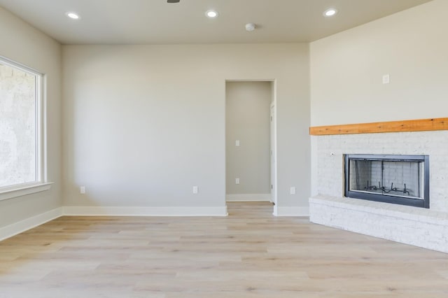 unfurnished living room featuring a fireplace and light hardwood / wood-style flooring