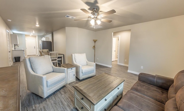 living room with sink, light hardwood / wood-style floors, and ceiling fan