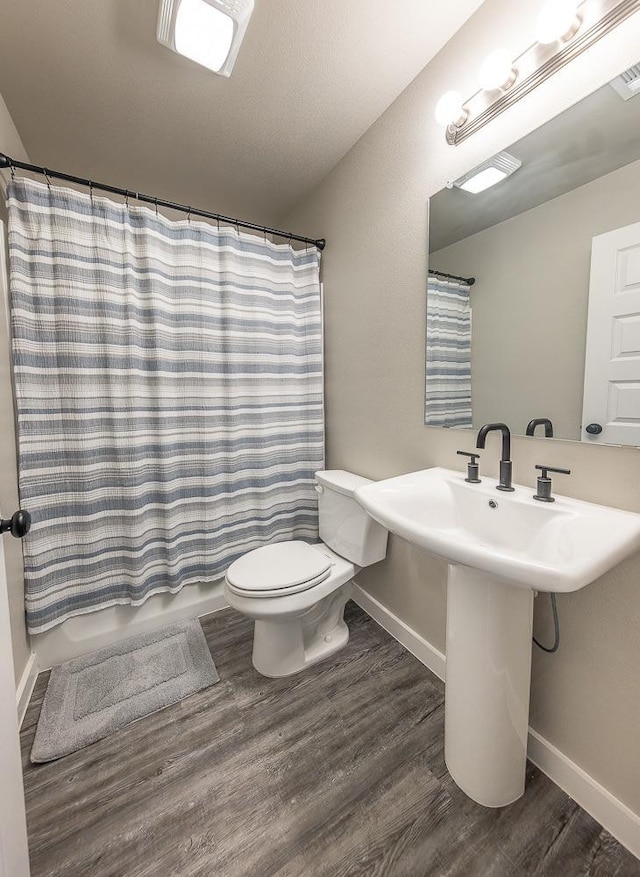 full bathroom with wood-type flooring, toilet, sink, and shower / bath combo