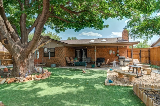 rear view of property featuring a yard and a patio