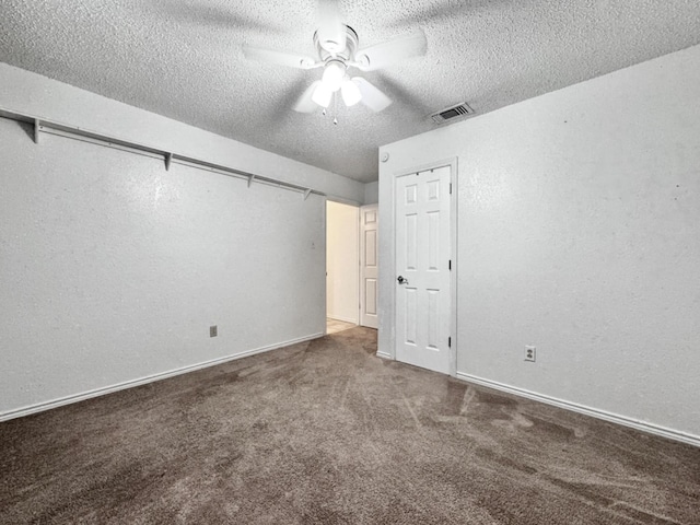 unfurnished room featuring dark colored carpet, ceiling fan, and a textured ceiling