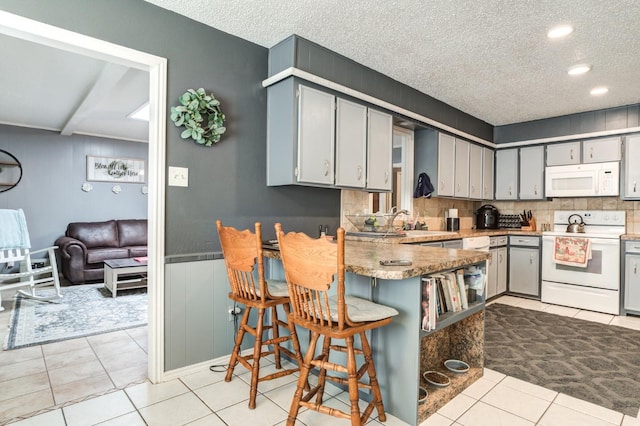 kitchen with gray cabinetry, a textured ceiling, white appliances, and kitchen peninsula