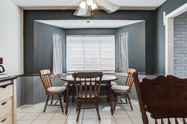 dining space featuring light tile patterned flooring, a textured ceiling, and a wealth of natural light