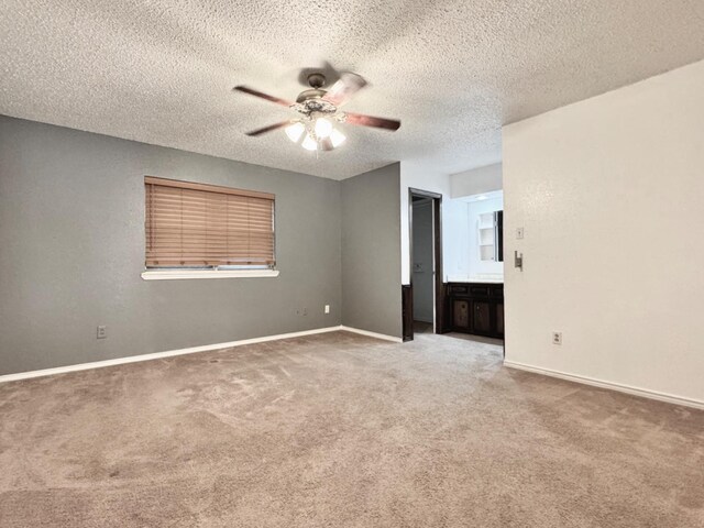 carpeted empty room with ceiling fan and a textured ceiling