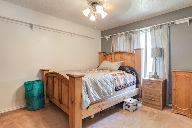 carpeted bedroom featuring ceiling fan and a textured ceiling