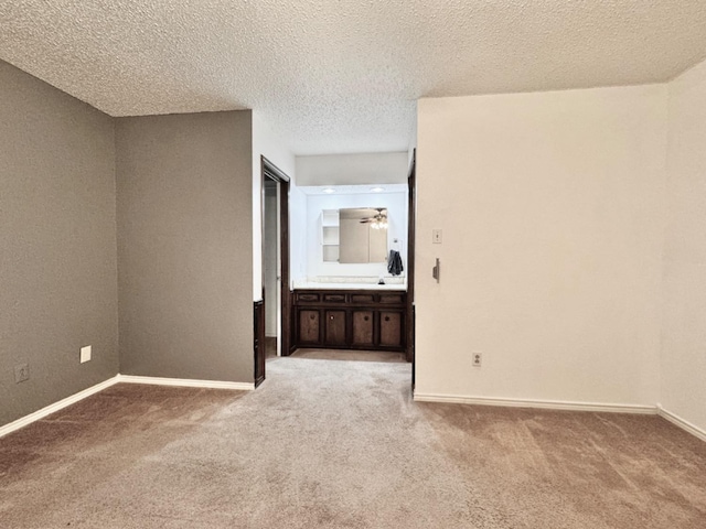 spare room featuring ceiling fan, a textured ceiling, and carpet flooring