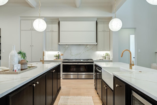 kitchen featuring decorative light fixtures, beamed ceiling, white cabinetry, dark brown cabinetry, and stainless steel range oven