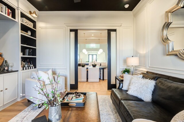 living room featuring wood-type flooring and crown molding