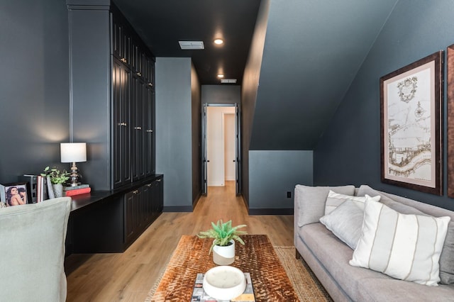 living room featuring vaulted ceiling and light hardwood / wood-style floors