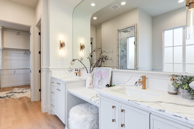 bathroom with hardwood / wood-style flooring, vanity, and an enclosed shower