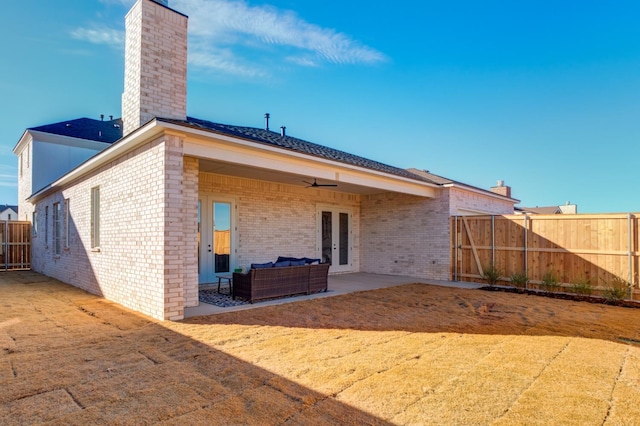 rear view of property featuring french doors, ceiling fan, an outdoor hangout area, and a patio area