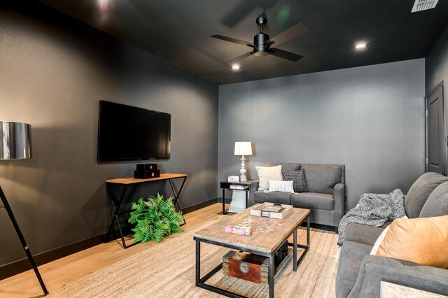 living room with light hardwood / wood-style flooring and ceiling fan