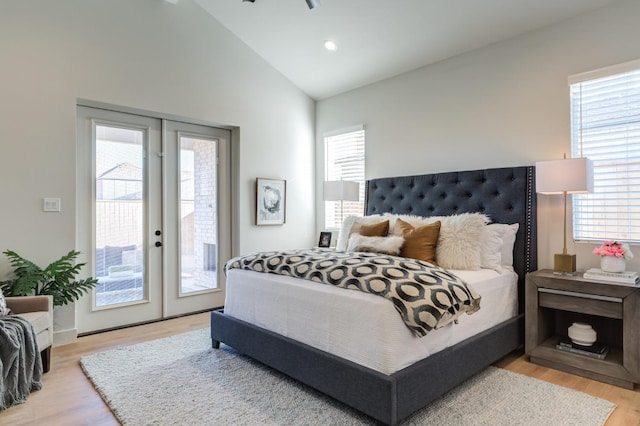 bedroom featuring light hardwood / wood-style flooring, access to outside, french doors, and vaulted ceiling