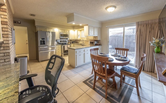 kitchen with light tile patterned flooring, appliances with stainless steel finishes, white cabinetry, sink, and ornamental molding