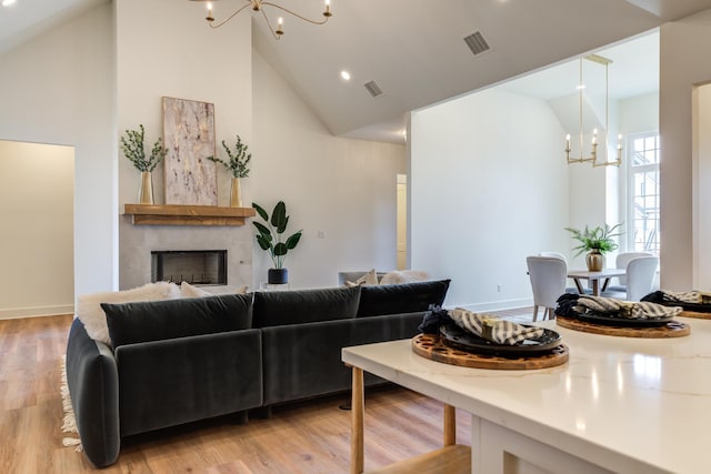4610 138th Pl, Lubbock, TX 79424 - living room with a chandelier, a fireplace, light wood-type flooring, high vaulted ceiling, and recessed lighting