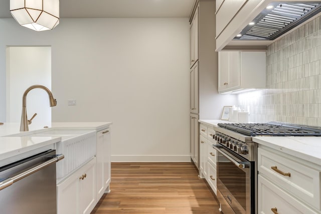 4610 138th Pl, Lubbock, TX 79424 - kitchen with stainless steel appliances, premium range hood, backsplash, light wood-style flooring, and light stone countertops