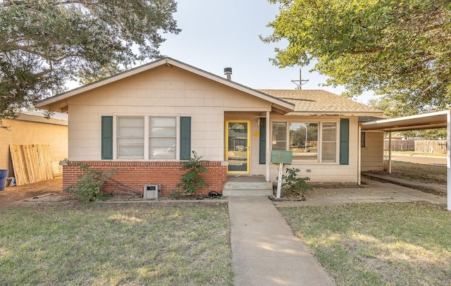 bungalow-style house with a carport and a front lawn