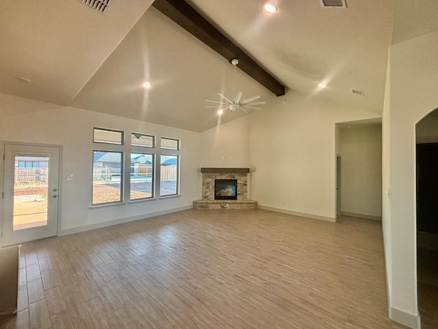 unfurnished living room featuring a stone fireplace, high vaulted ceiling, beamed ceiling, ceiling fan, and light hardwood / wood-style floors