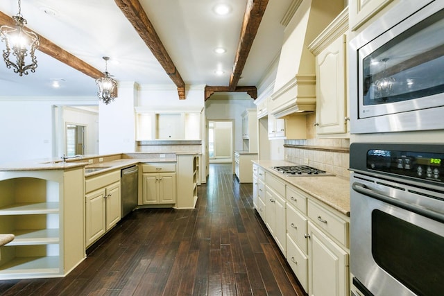 kitchen with sink, an inviting chandelier, decorative light fixtures, appliances with stainless steel finishes, and cream cabinets