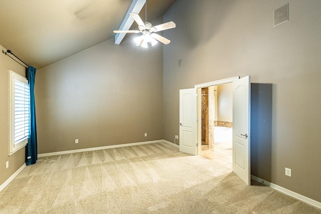 unfurnished room with ceiling fan, light colored carpet, beam ceiling, and high vaulted ceiling