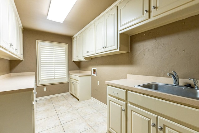 washroom featuring cabinets, light tile patterned flooring, sink, and washer hookup