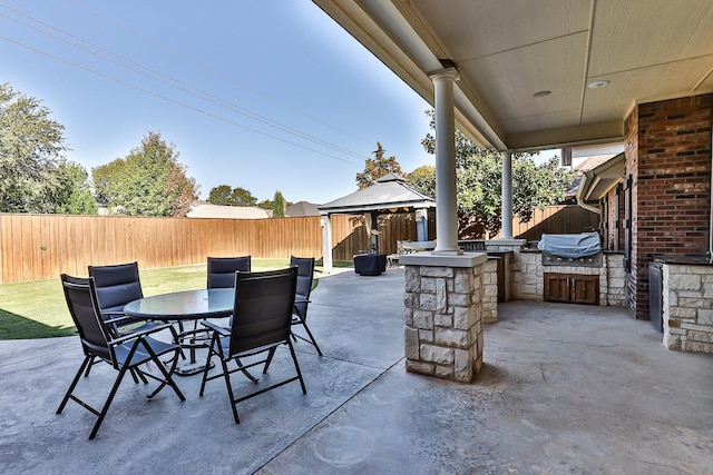 view of patio / terrace featuring a gazebo, an outdoor kitchen, and a grill