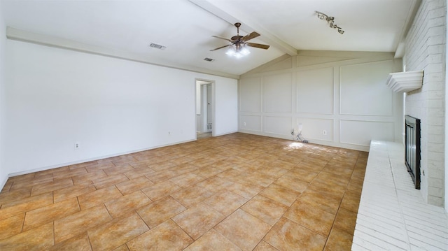 unfurnished living room with a brick fireplace, light tile patterned floors, vaulted ceiling with beams, and ceiling fan