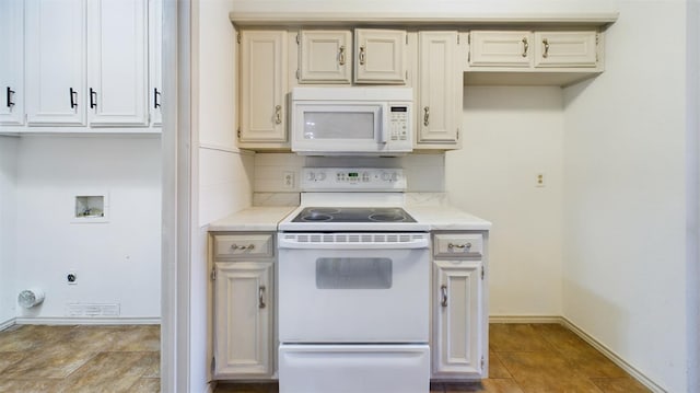 kitchen featuring light tile patterned floors, white appliances, and decorative backsplash