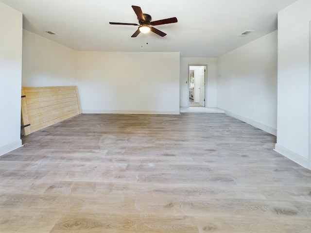 empty room with ceiling fan and light hardwood / wood-style flooring