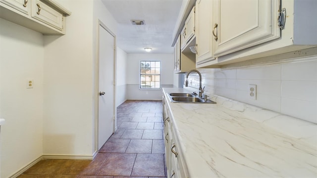 kitchen with tile patterned flooring, sink, and decorative backsplash