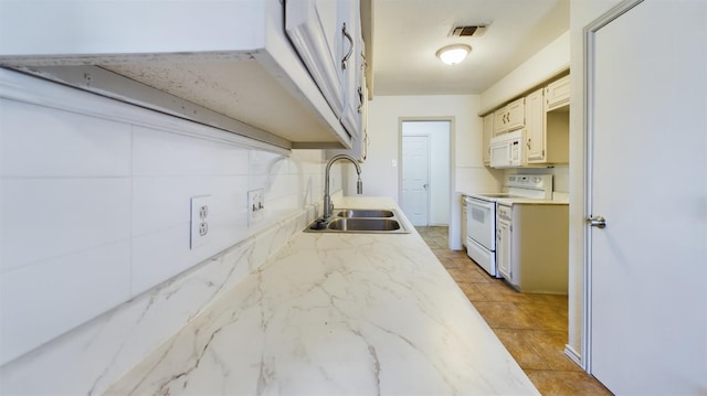 kitchen featuring sink, white appliances, and backsplash