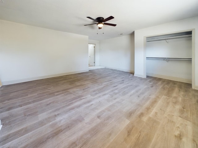 unfurnished bedroom featuring ceiling fan, a closet, and light hardwood / wood-style flooring