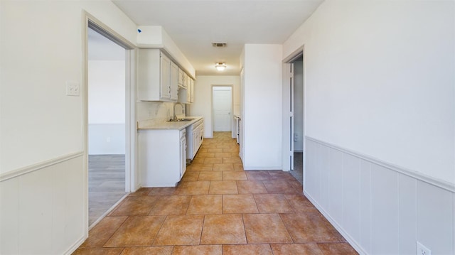 corridor featuring sink and light tile patterned floors