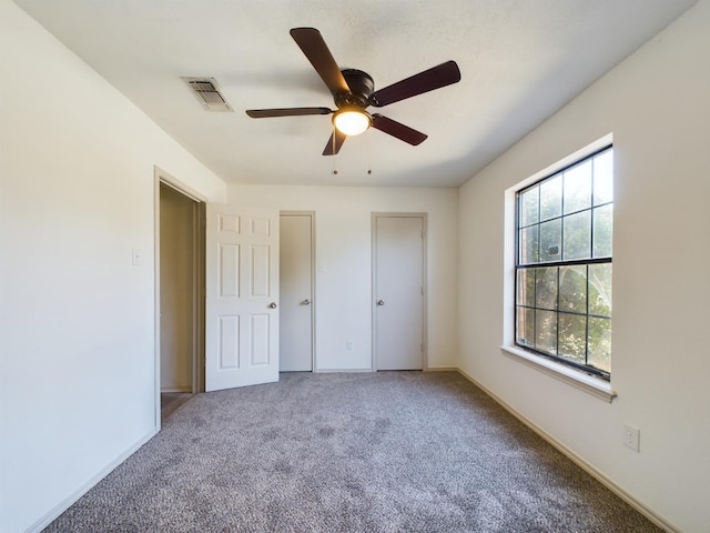 unfurnished bedroom with ceiling fan and carpet floors