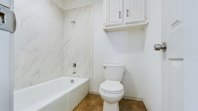 bathroom featuring tile patterned flooring, tiled shower / bath combo, and toilet