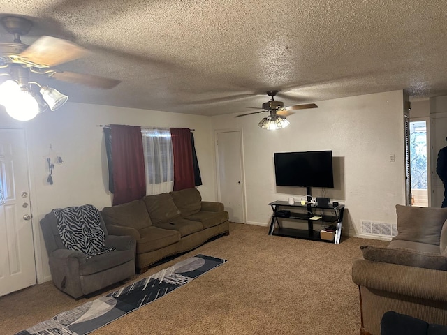 living room with ceiling fan, carpet floors, and a textured ceiling