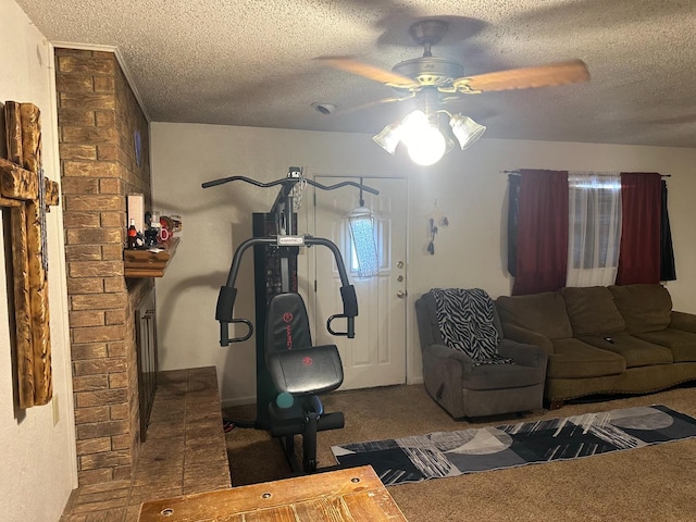 exercise area with ceiling fan, carpet floors, and a textured ceiling